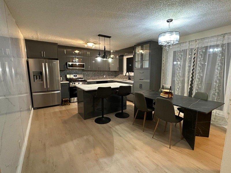 Dark island kitchen with pendant lighting by Monarch Cabinets