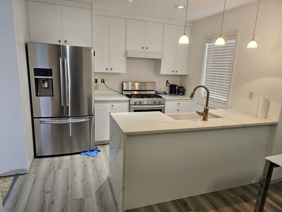 White shaker kitchen with waterfall quartz island Saskatoon