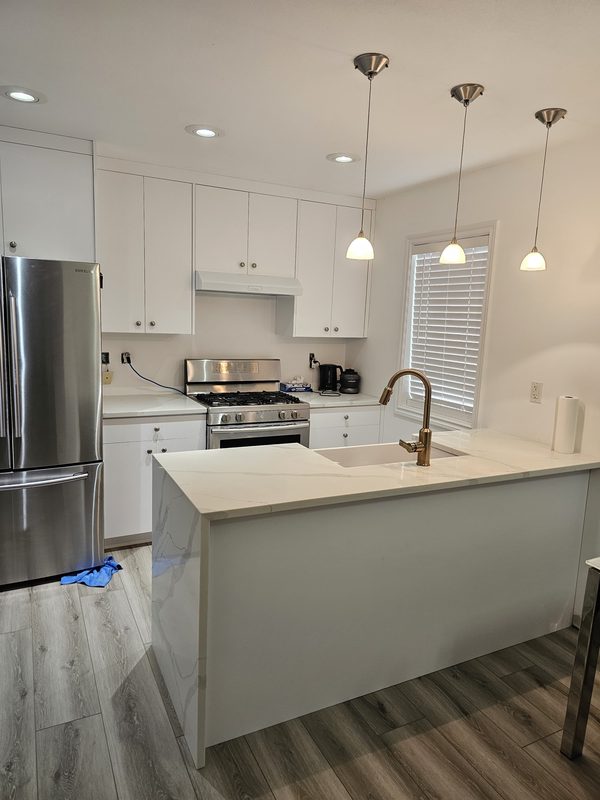 White shaker kitchen with waterfall quartz island